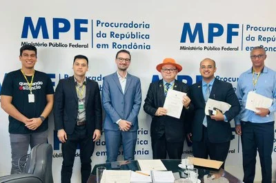 Foto mostra seis homens com roupas formais em pé lado a lado na frente do banner do MPF
